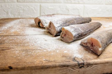 Tahtada un ile kaplanmış çiğ balık parçaları pişirmek için hazırlandı.