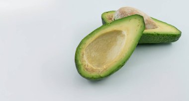 Yarım avokado, beyaz arka planda izole edilmiş taze sağlıklı gıda konsepti.