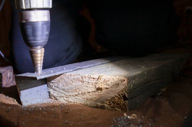 Metal basamak matkap ucu atölyedeki ahşap kirişe sabitlenmiş çelik levha.