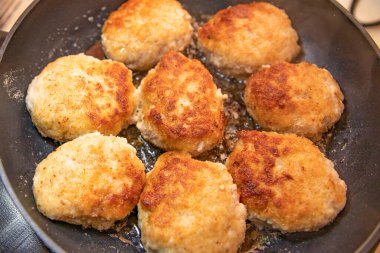 Ev yapımı yemek hazırlıkları sırasında tavada pişen altın kızarmış tavuk pirzolası.