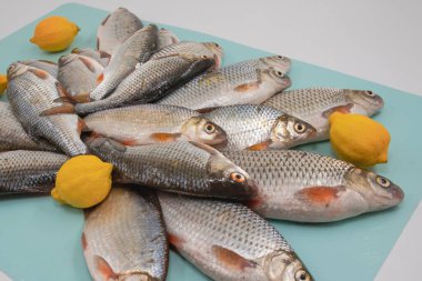 Açık arkaplanda taze limonlarla düzenlenmiş balık hamamböceği.