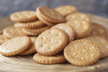 Tahta servis panosuna istiflenmiş yuvarlak tuzlu krakerler.