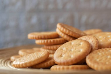 Tahta servis panosuna istiflenmiş yuvarlak tuzlu krakerler.