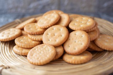 Tahta servis panosuna istiflenmiş yuvarlak tuzlu krakerler.