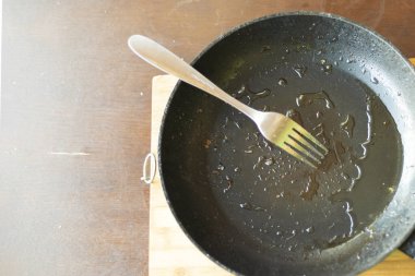 Yağlı kızartma tavası ve yağ kalıntısı sağlıksız yağ diyeti ve yüksek kolesterol riskini simgeliyor.