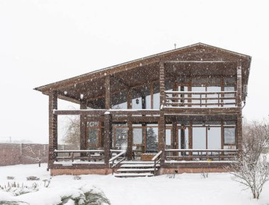 Kışın kar gayrimenkul satışında modern ahşap evin dış görünüşü