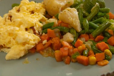 Fırında balık, erimiş peynir ve karışık sebze sağlıklı bir akşam yemeği.