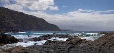 Vahşi Atlantik okyanus dalgaları volkanik kayalık kıyı şeridine çarpıyor.