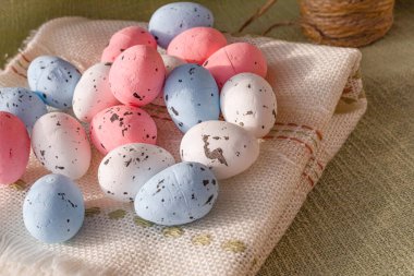 Pastel Paskalya yumurtaları. Kırsal keten kumaş kumaşında benekli desenli. Bahar tatili dekorasyonu.