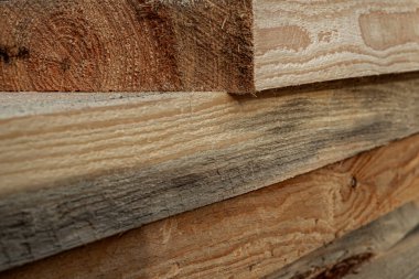 Doğal kereste dokusunu gösteren kaba kesilmiş ahşap tahtalar yığını.