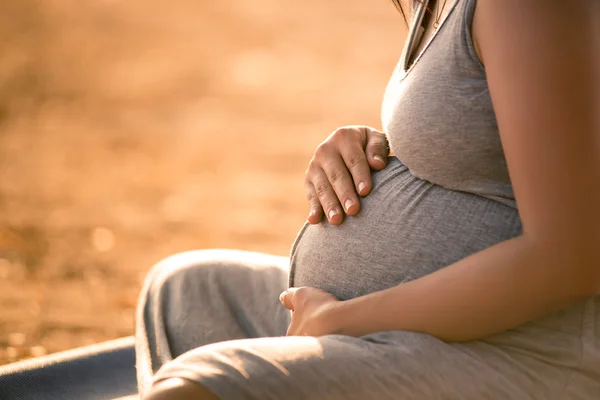 Hamile kadın göl günbatımı arka plan rahatlatıcı — Stok fotoğraf
