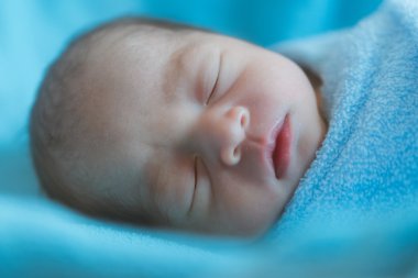 Yeni doğan bebek uyku sırasında Asya mavi bezle kaplı