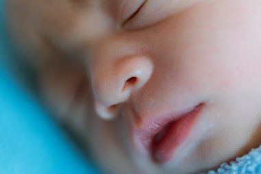 Yeni doğan bebek uyku sırasında Asya mavi bezle kaplı