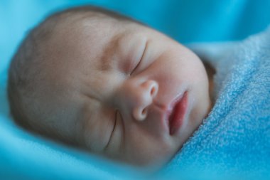 Yeni doğan bebek uyku sırasında Asya mavi bezle kaplı