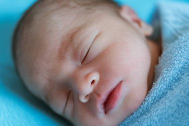Yeni doğan bebek uyku sırasında Asya mavi bezle kaplı