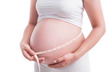 hamile kadın 9 ay karnında beyaz bir arka plan ölçme.