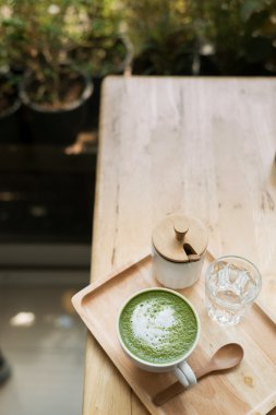 Sıcak yeşil çay bir coffeshop ahşap bir masa ayarlamak
