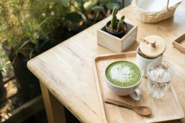 Sıcak yeşil çay bir coffeshop ahşap bir masa ayarlamak