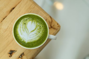 Sıcak yeşil çay bir coffeshop ahşap bir masa ayarlamak