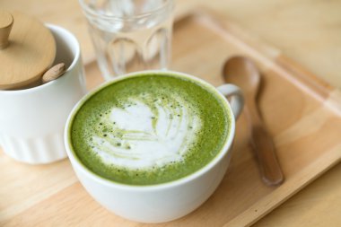 Sıcak yeşil çay bir coffeshop ahşap bir masa ayarlamak