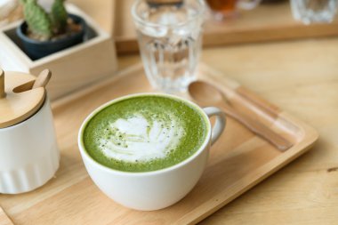 Sıcak yeşil çay bir coffeshop ahşap bir masa ayarlamak