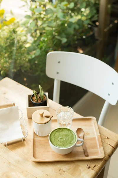 Sıcak yeşil çay bir coffeshop ahşap bir masa ayarlamak