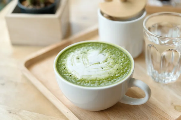 Sıcak yeşil çay bir coffeshop ahşap bir masa ayarlamak
