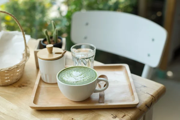Varmt grönt te på ett träbord i en coffeshop — Stockfoto