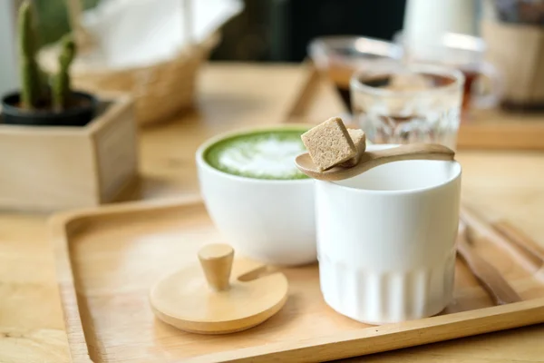 Varmt grönt te på ett träbord i en coffeshop — Stockfoto