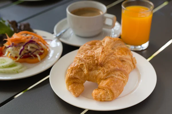 Kruvasan kahvaltı servisi ile siyah kahve ve kahvaltı menüsü. — Stok fotoğraf