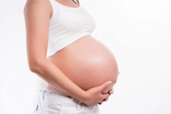 Pregnant woman holding ultrasound scan on her tummy — Stock Photo, Image