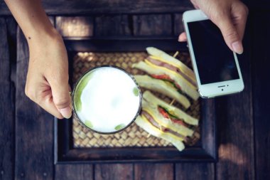 Matcha yeşil çay kahve ve kullanım cep telefonu tutan kadın