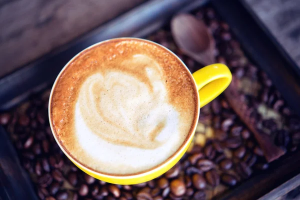 Café mocha quente e grãos de café na mesa de madeira — Fotografia de Stock