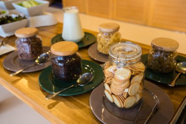 Crispy cereal, various types of glass bottles served buffet.
