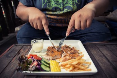 Şişman adam yiyen domuz biftek bir kafede