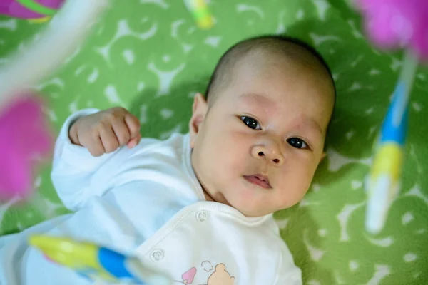 Ázsiai baby feküdt az ágyban hal mobil lógó. — Stock Fotó