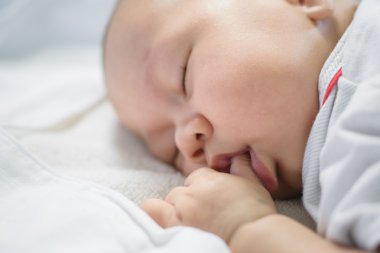 Asya bebek beyaz nevresim uyku.