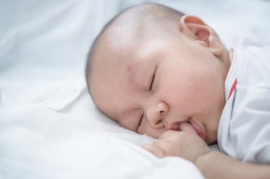 Asya bebek beyaz nevresim uyku.