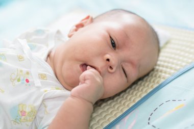 Asya bebek uyku emmek beyaz yatak çarşafları olduğunu.