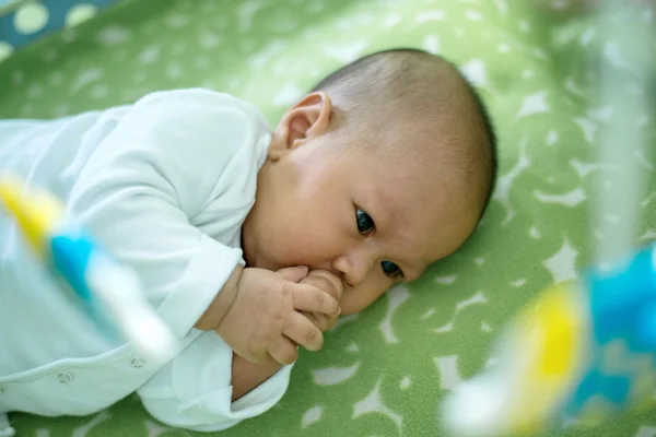 Asiático bebé acostado en la cama peces móvil colgando . — Foto de Stock
