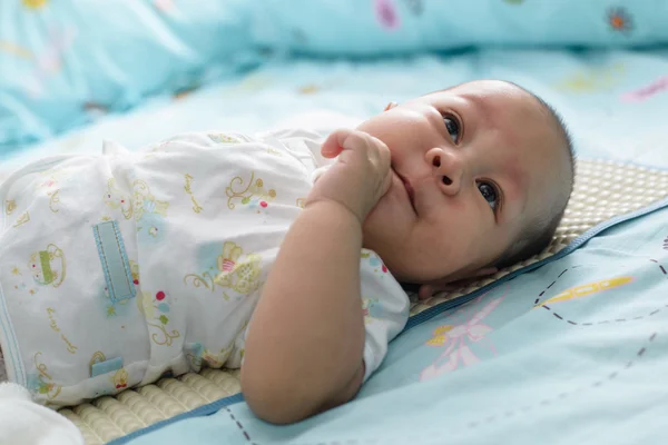 Bayi Asia tidur adalah mengisap linen tempat tidur putih . — Stok Foto