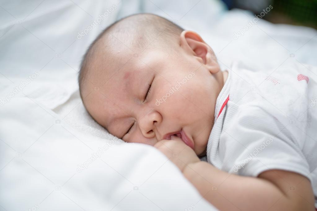 Asian baby sleeping white bed linen. Stock Photo by ©aengza001gmail