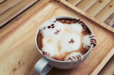 Bir ayıya sıcak süt sıcak Latte sanat getiriyor.