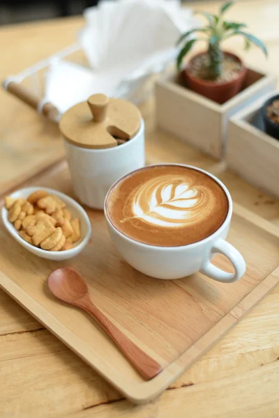 Arte del latte caldo con cactus in caffetteria sul tavolo di legno — Foto Stock
