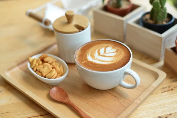 Arte del latte caldo con cactus in caffetteria sul tavolo di legno — Foto Stock