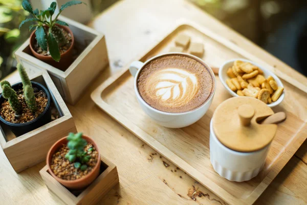 Arte del latte caldo con cactus in caffetteria sul tavolo di legno — Foto Stock