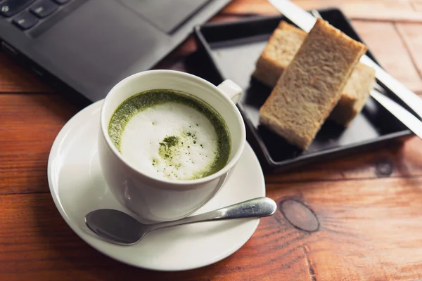 Green tea is served with hot bread between the notebook. — Stock Photo, Image