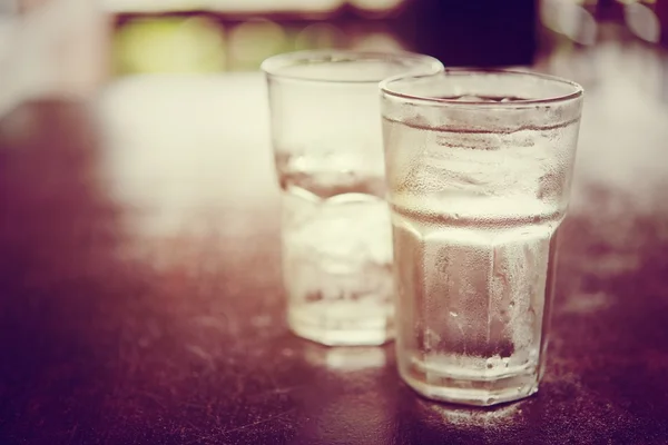 Beber agua fría en un vaso de tres colocado en la mesa de madera — Foto de Stock