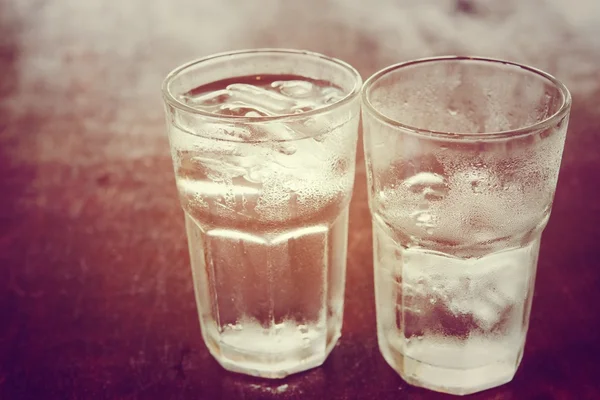 Beber agua fría en un vaso de tres colocado en la mesa de madera — Foto de Stock