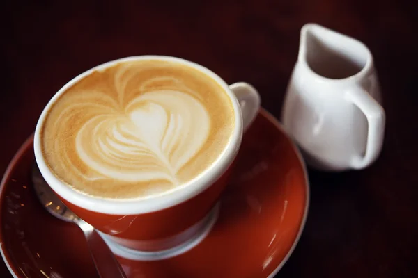 Café quente com leite na cafeteria na mesa de madeira — Fotografia de Stock